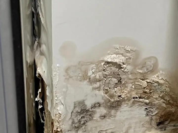נזקי רטיבות והתקלפות בפינת קיר ורצפה
